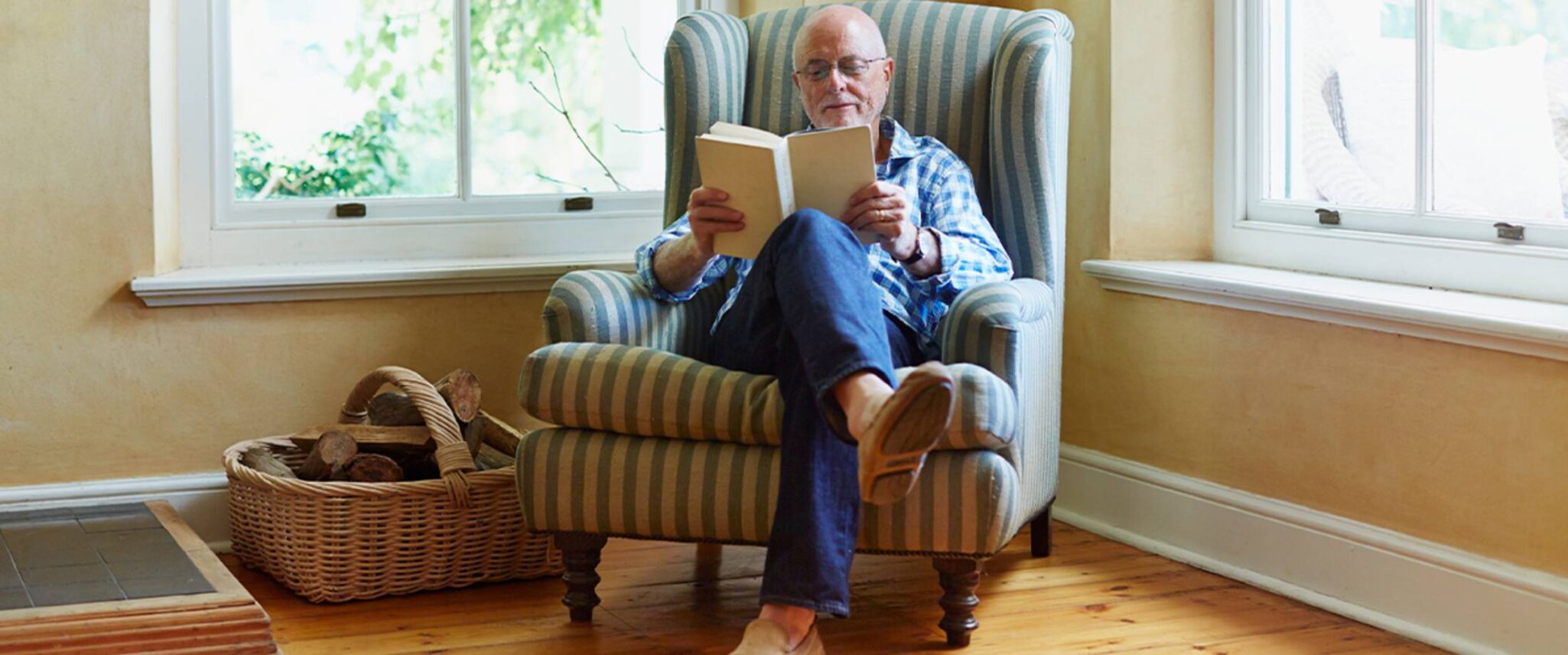 senior man reading a book in his senior living apartment