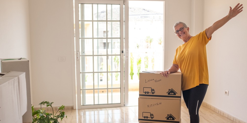 senior woman unpacking boxes in new home