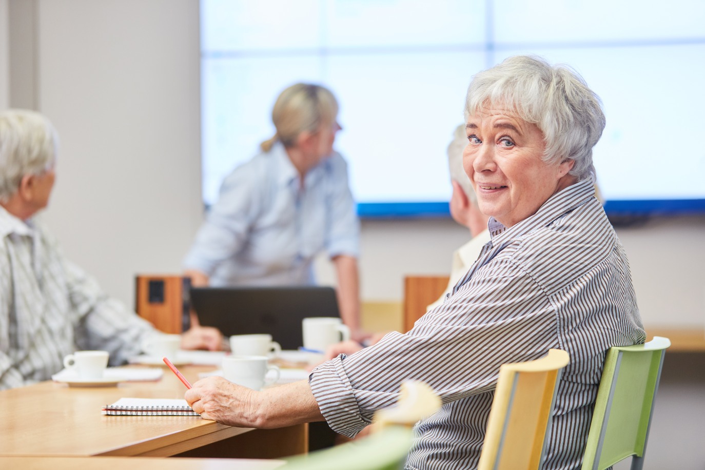 Smiling senior woman in adult education in a seminar at the adult education center