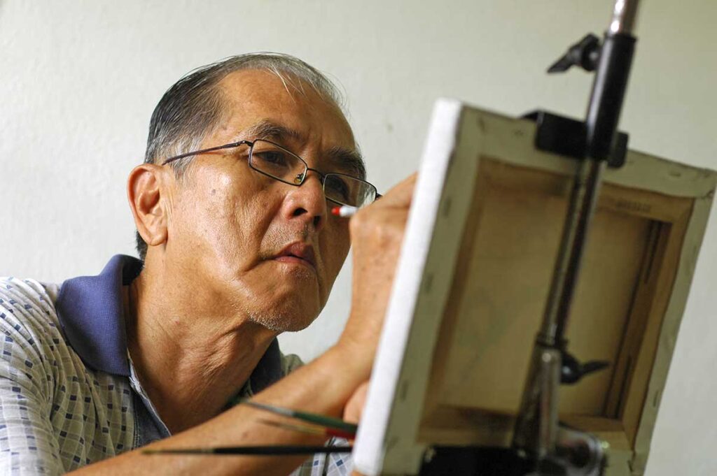 senior man focusing on his painting