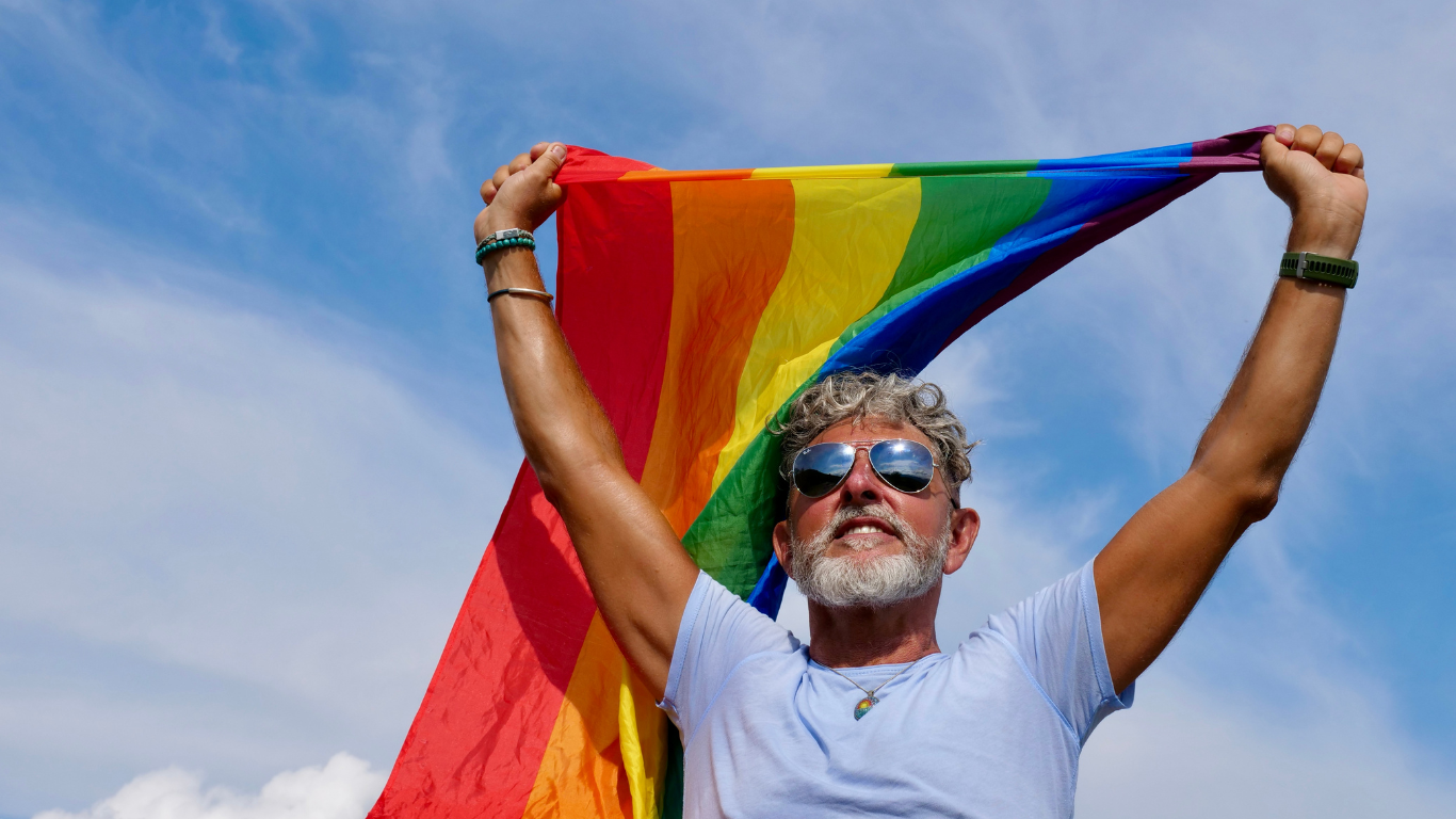 Blog Images (80) Man holds up pride flag behind him
