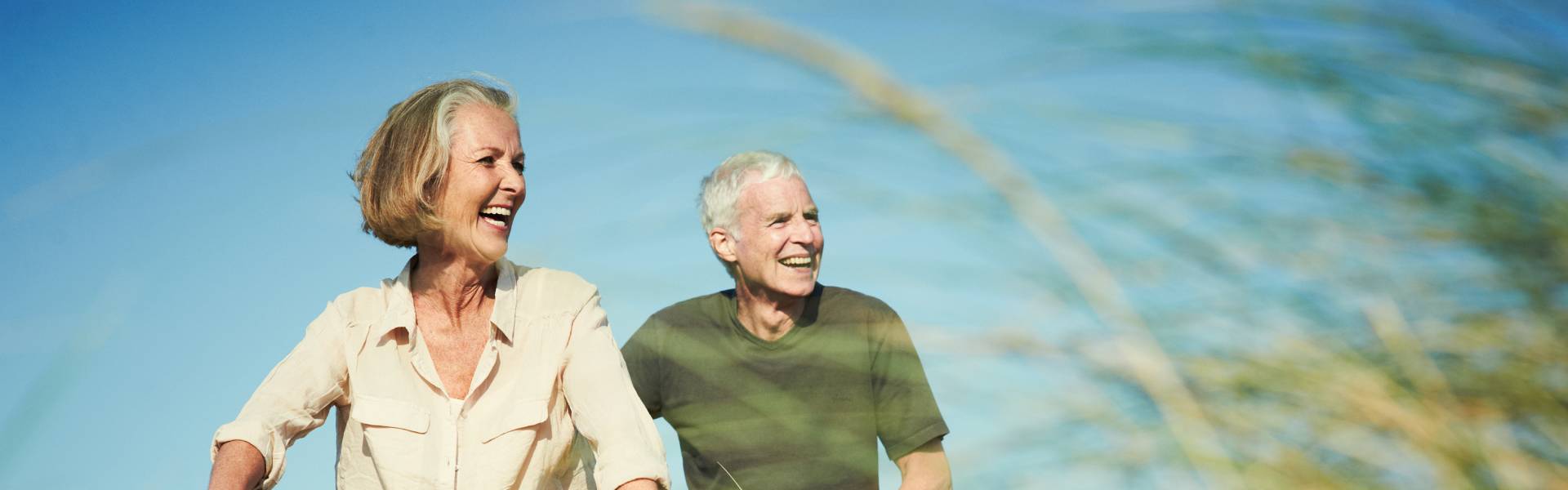 happy older couple riding bikes on a dirt trail