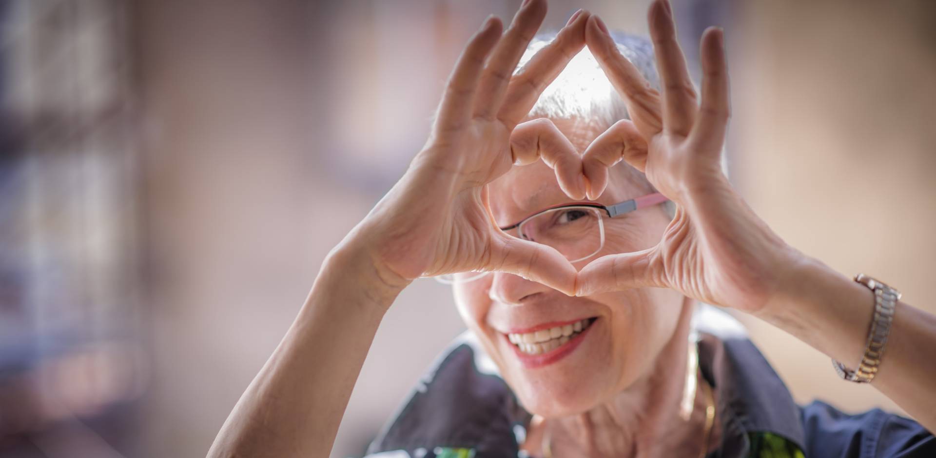 senior lady making a heart with her hands