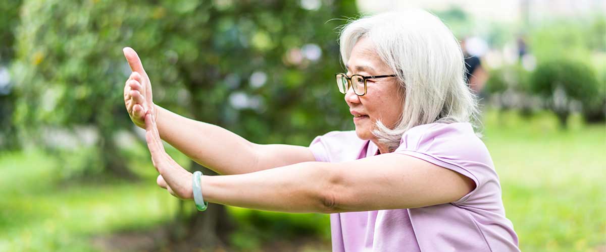 Senior woman practicing Tai Chi outdoors