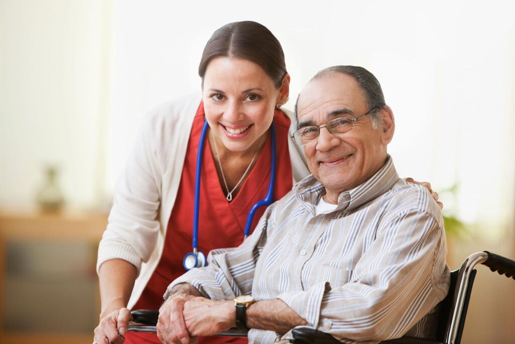 senior man in a wheelchair smiling with a health care worker