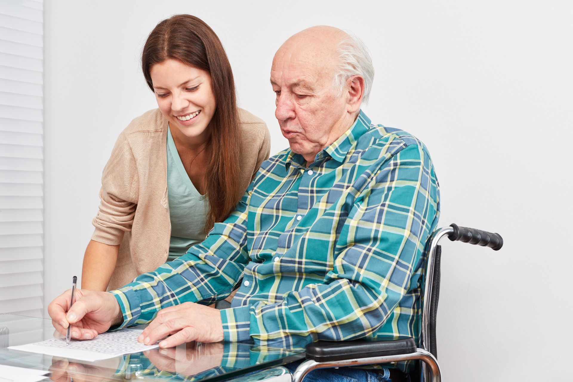 Elderly man solves puzzle with caregiver