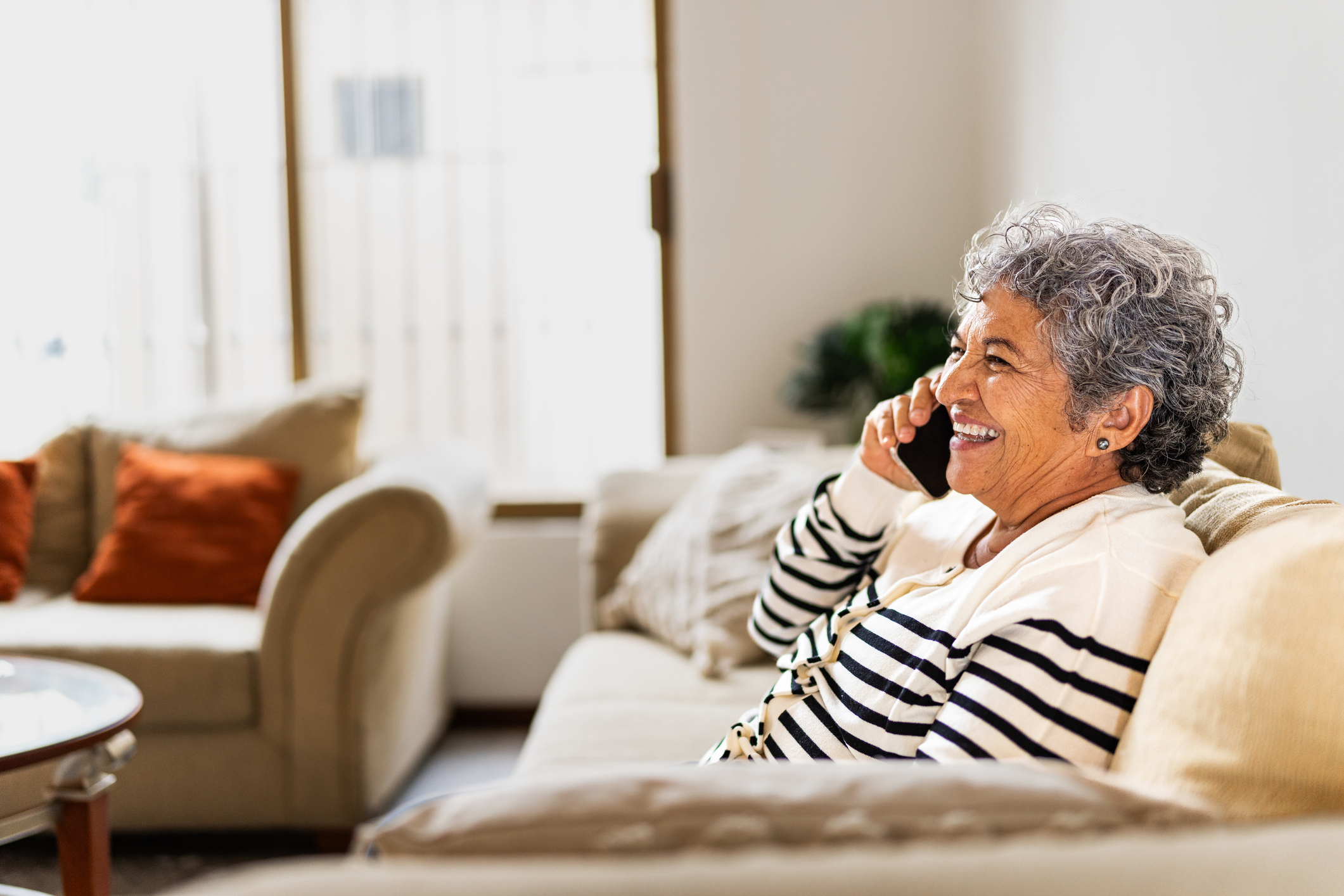Senior woman talking on a mobile phone at home